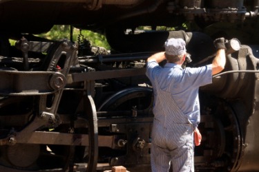 A railroad engineer working in his locomotive.